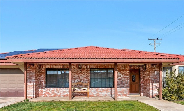 view of front of house featuring a garage, a front lawn, and solar panels