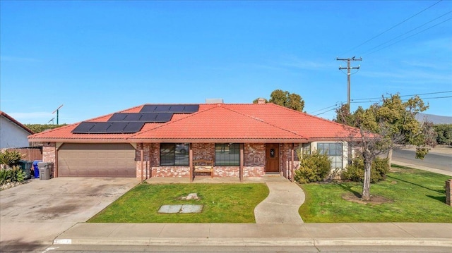 view of front facade featuring a garage, a front lawn, and solar panels