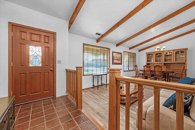 entryway with vaulted ceiling with beams and a notable chandelier