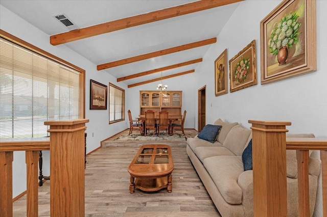 living room featuring an inviting chandelier, light hardwood / wood-style flooring, and vaulted ceiling with beams