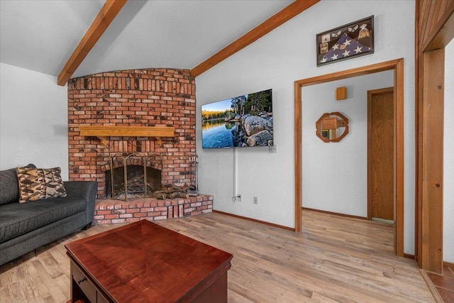 living room featuring a fireplace, light hardwood / wood-style floors, and lofted ceiling with beams