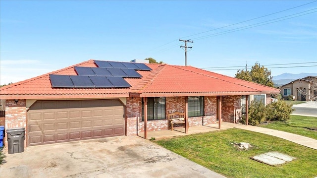 view of front of house with solar panels, a front yard, a porch, and a garage