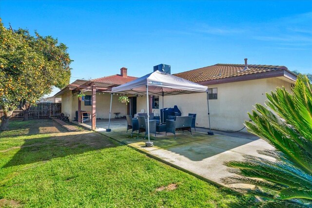 rear view of house featuring a yard and a patio