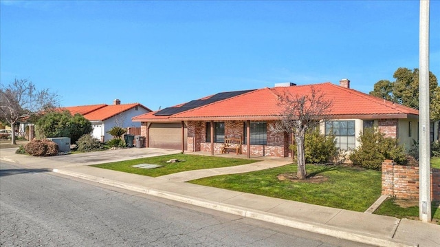 single story home featuring a garage, a front lawn, solar panels, and a porch