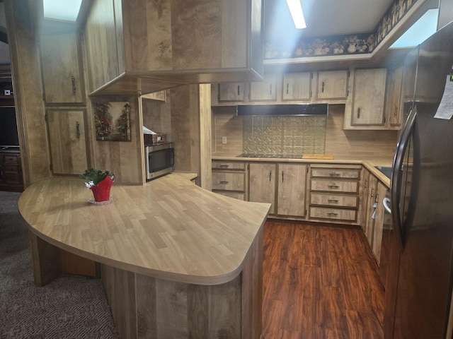 kitchen with a skylight, black electric cooktop, range hood, and fridge