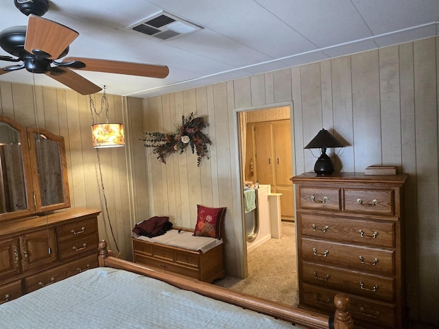 carpeted bedroom with ceiling fan and wooden walls