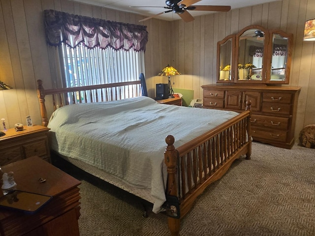 bedroom featuring ceiling fan, wooden walls, and carpet flooring