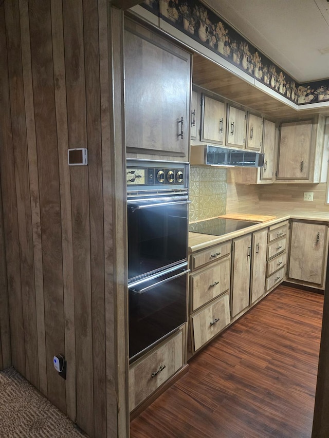 kitchen with black appliances, extractor fan, and dark hardwood / wood-style flooring