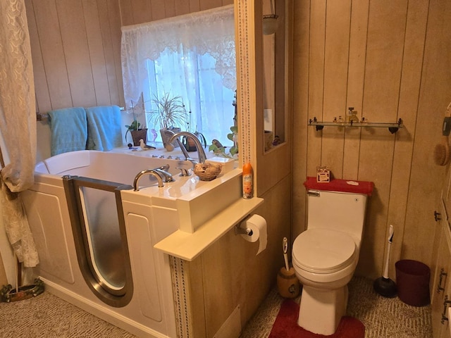 bathroom featuring toilet and wood walls