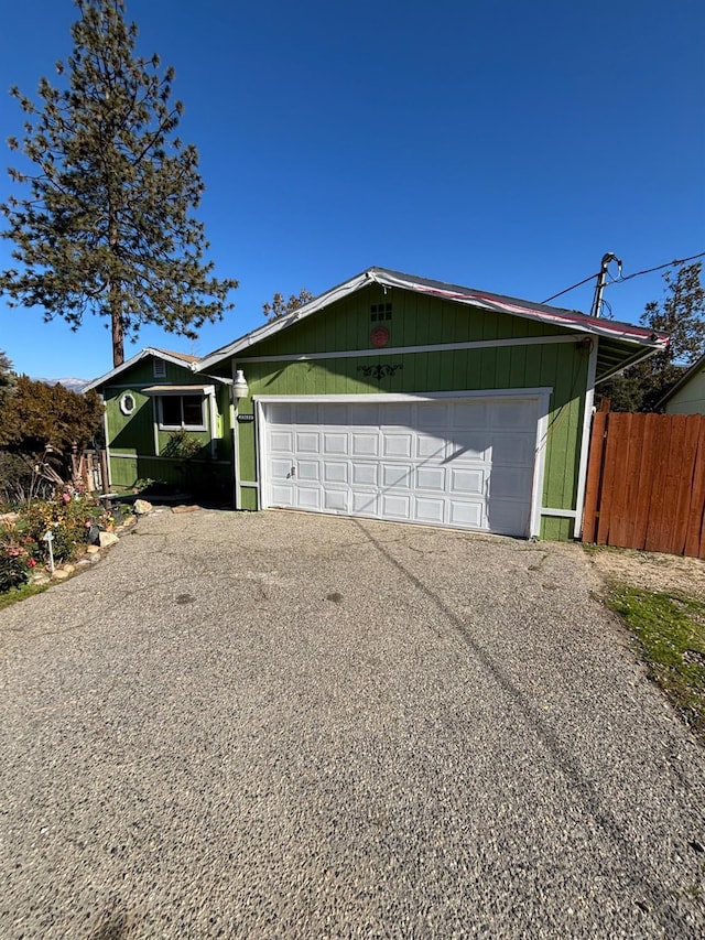 view of front of house with an attached garage, fence, and aphalt driveway