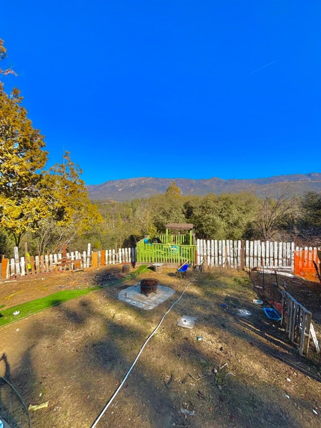 view of yard featuring fence and a mountain view