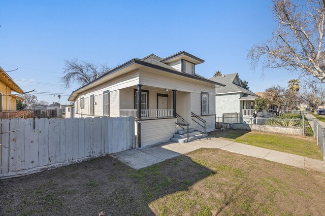 bungalow-style home with covered porch and a front yard