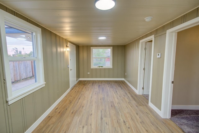 empty room with plenty of natural light and light hardwood / wood-style flooring