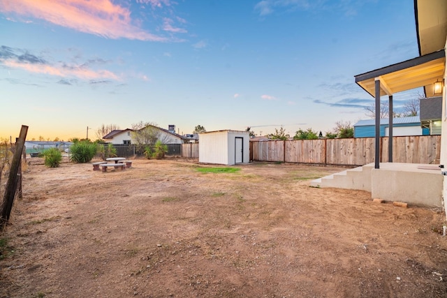 yard at dusk featuring a shed