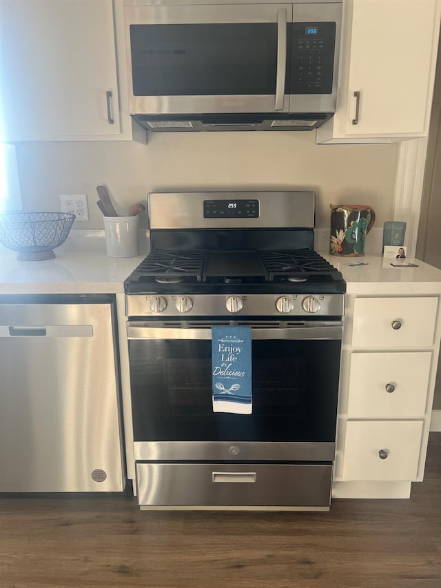 kitchen featuring white cabinets, appliances with stainless steel finishes, and dark hardwood / wood-style flooring