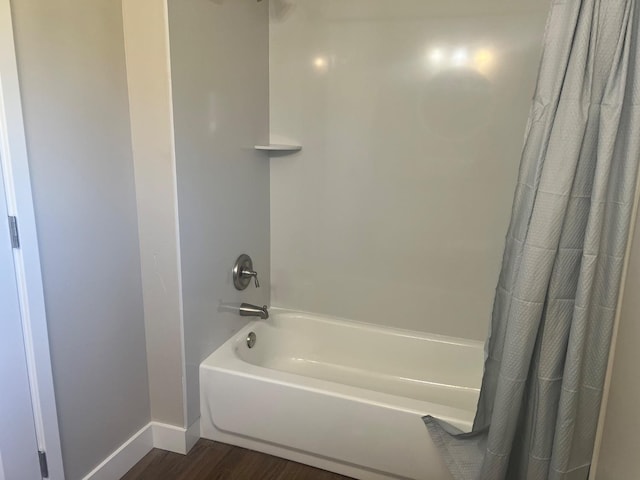 bathroom with hardwood / wood-style flooring and shower / tub combo