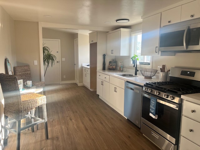 kitchen with dark wood-type flooring, sink, white cabinets, and stainless steel appliances