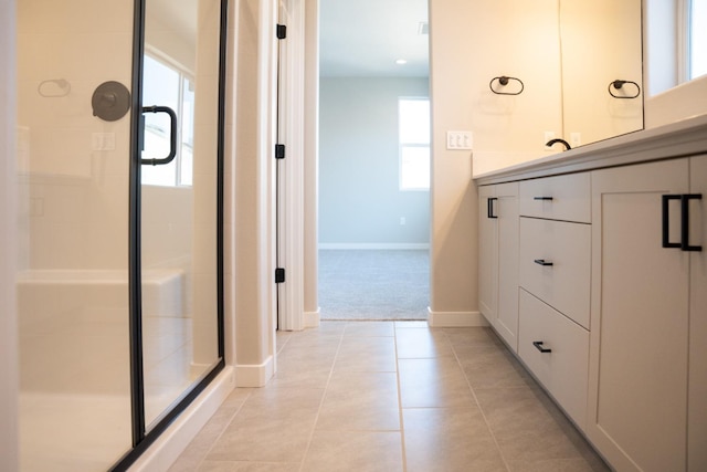 bathroom featuring a shower with shower door, tile patterned floors, and vanity