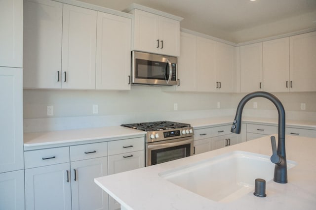 kitchen with sink, white cabinetry, and stainless steel appliances