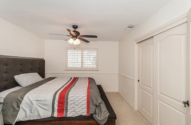 carpeted bedroom with ceiling fan and a closet