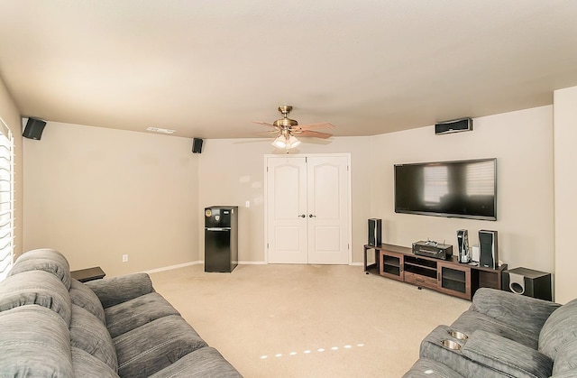 carpeted living room with ceiling fan