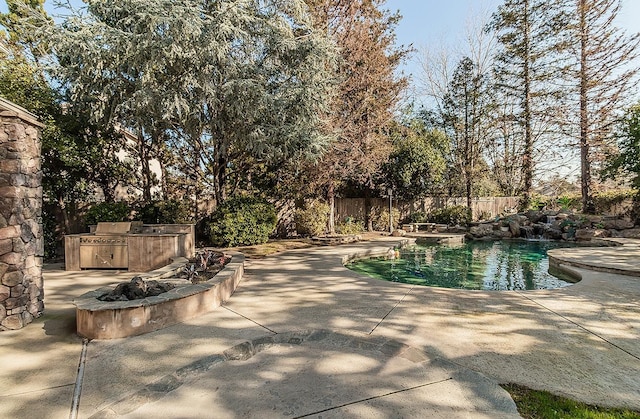 view of pool featuring grilling area, a patio area, and an outdoor kitchen