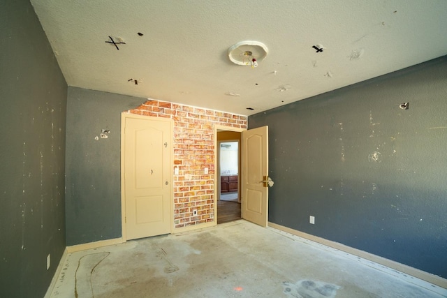 empty room featuring brick wall