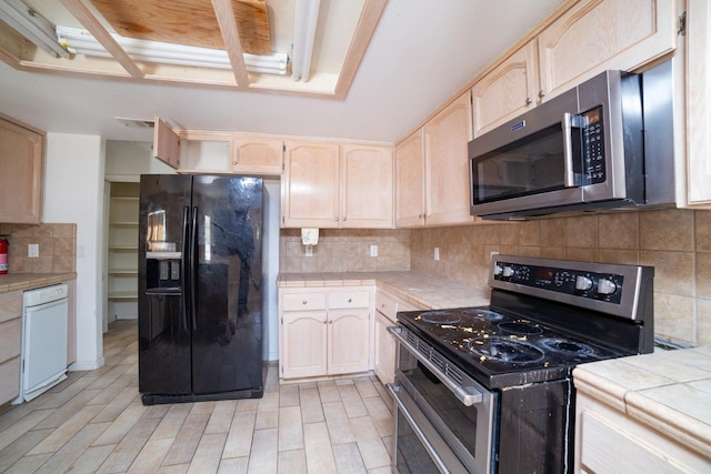 kitchen with backsplash, light brown cabinets, appliances with stainless steel finishes, and tile countertops