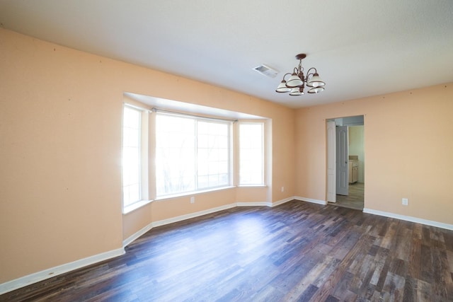 unfurnished room with dark hardwood / wood-style flooring and an inviting chandelier