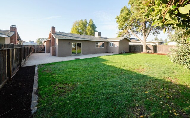 back of property with a lawn and a patio