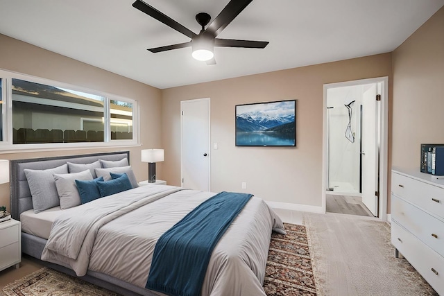 bedroom featuring light wood-style floors, ensuite bath, baseboards, and a ceiling fan