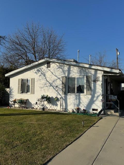 view of side of property with a lawn