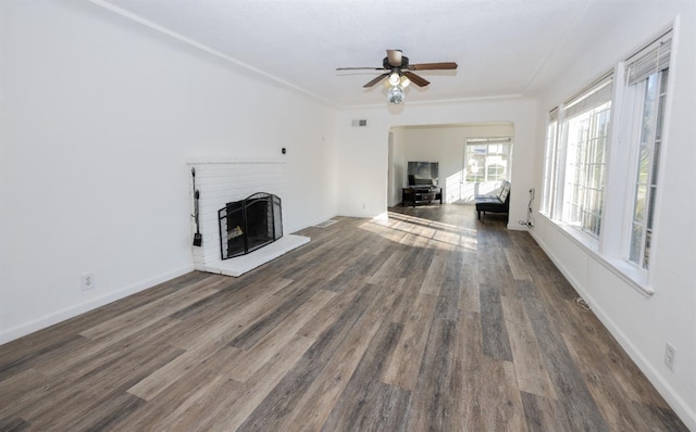 unfurnished living room with ceiling fan, a brick fireplace, and dark hardwood / wood-style flooring