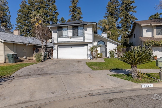 view of front property featuring a garage, a front yard, and solar panels