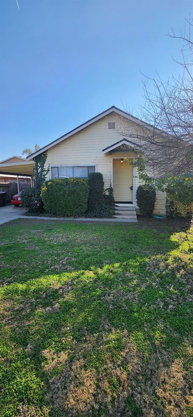 view of front facade with a carport and a front lawn