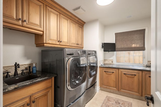 laundry room with cabinets, washer and dryer, sink, and light tile patterned floors