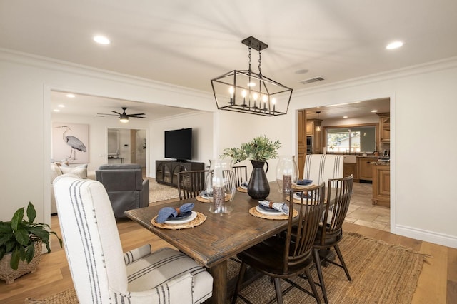 dining space featuring ornamental molding, ceiling fan, and light wood-type flooring