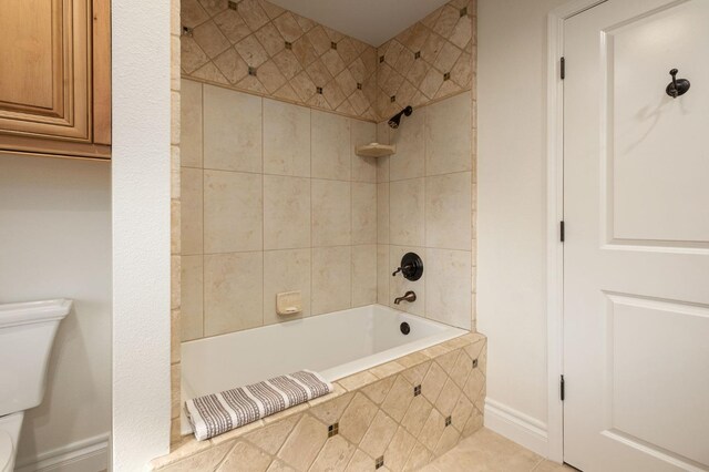 bathroom with tile patterned floors, toilet, and tiled shower / bath