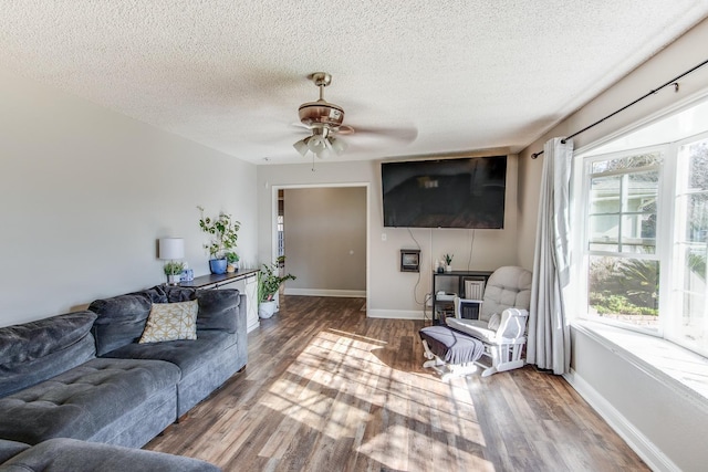 living area with a wealth of natural light, baseboards, and wood finished floors