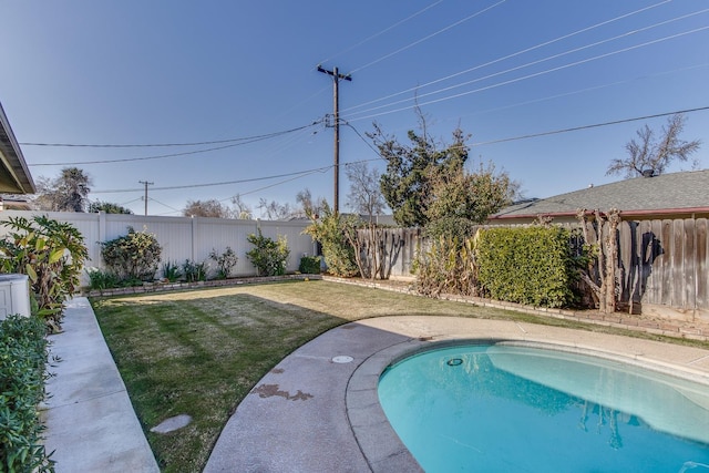 view of pool with a lawn and a fenced backyard