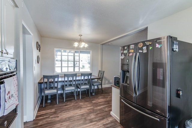 kitchen with a chandelier, oven, dark wood-style flooring, white cabinetry, and stainless steel fridge with ice dispenser