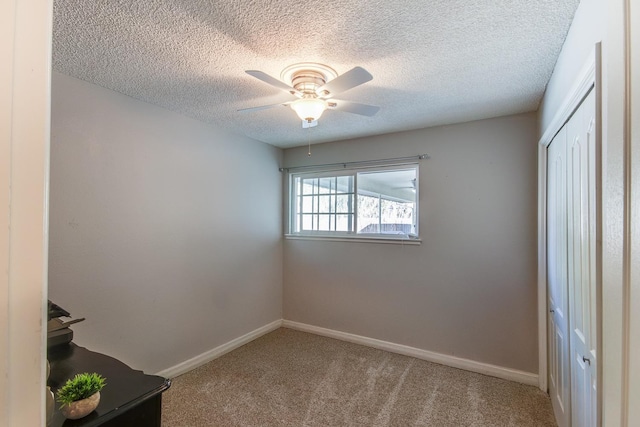 interior space with a textured ceiling, a ceiling fan, and baseboards