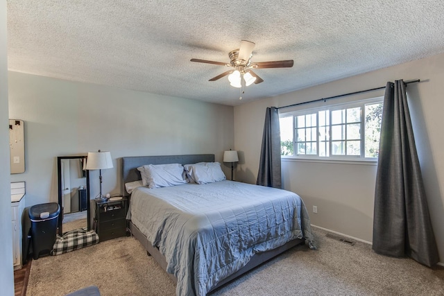 carpeted bedroom featuring baseboards, a textured ceiling, visible vents, and a ceiling fan