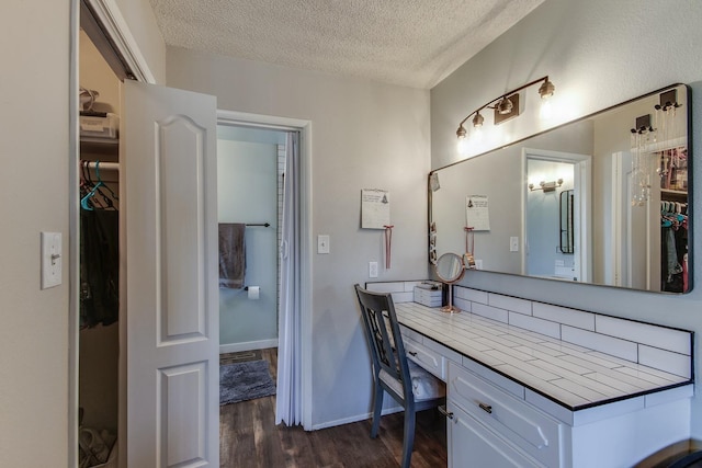 bathroom featuring vanity, a textured ceiling, baseboards, and wood finished floors