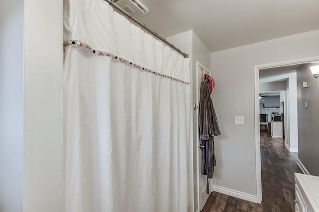 bathroom with a shower with shower curtain, baseboards, and wood finished floors