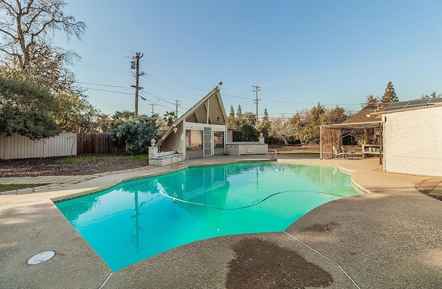 view of pool with a patio and an outbuilding