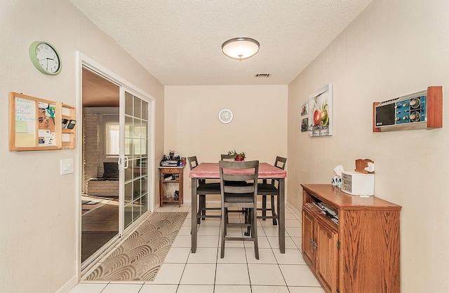 tiled dining area with a textured ceiling