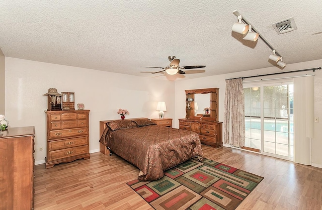 bedroom featuring access to exterior, a textured ceiling, ceiling fan, and light wood-type flooring