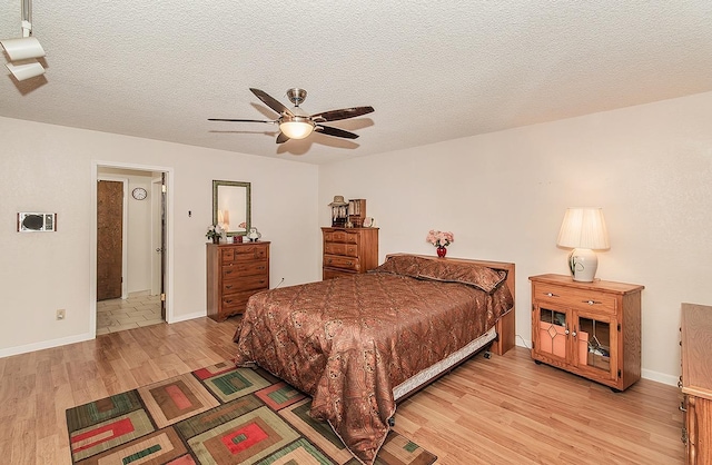 bedroom featuring a textured ceiling, light hardwood / wood-style flooring, and ceiling fan