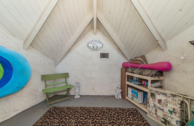 additional living space featuring concrete flooring and lofted ceiling with beams